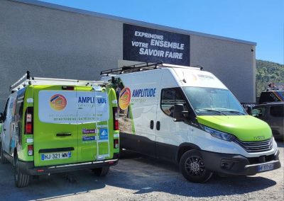 Covering véhicule pour Amplitude Énergie : deux utilitaires floqués aux couleurs vert et blanc de la société, devant les locaux d'Ardesca Print