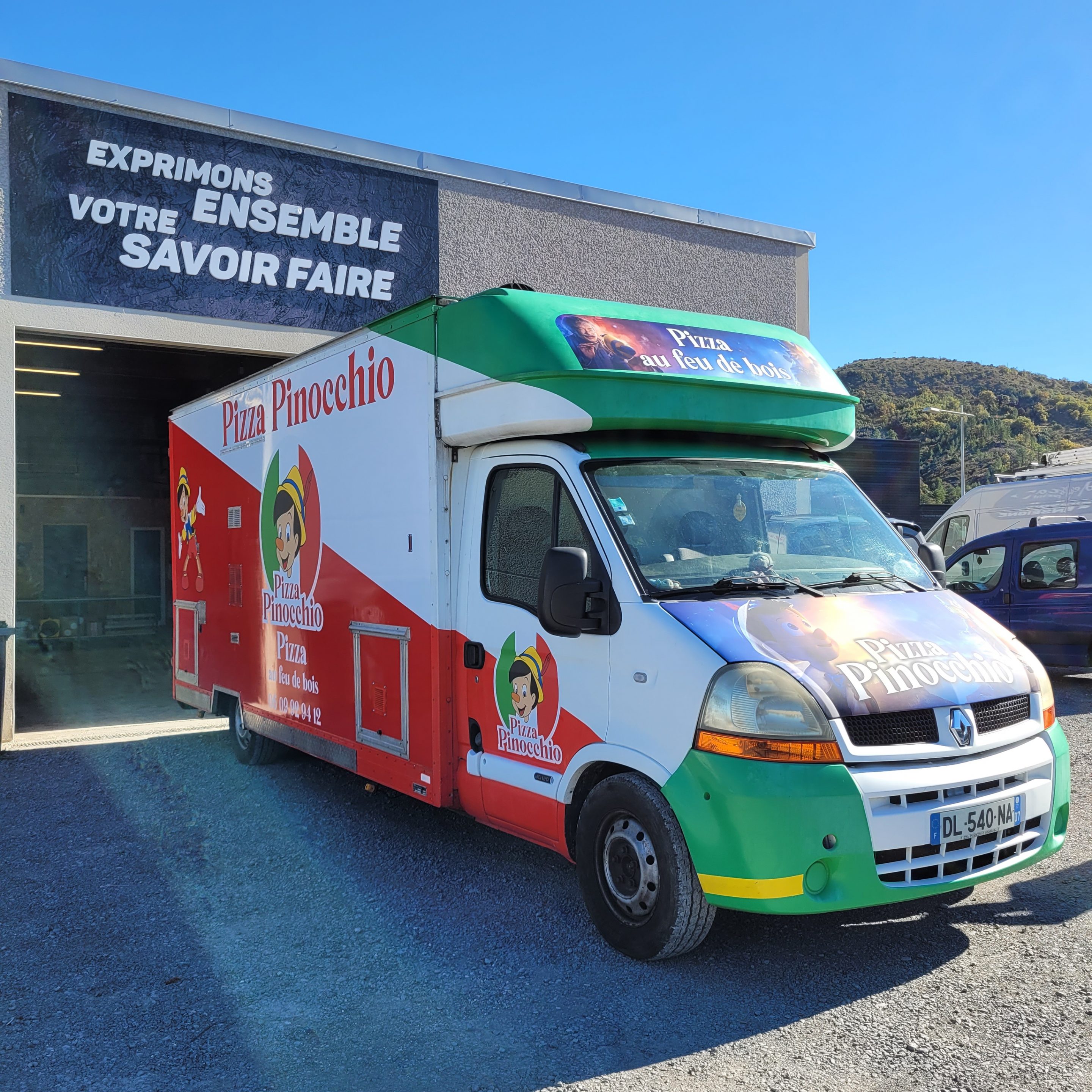Covering complet d'un camion pizza Renault Master aux couleurs vert, blanc et rouge de Pizza Pinocchio, pizza au feu de bois