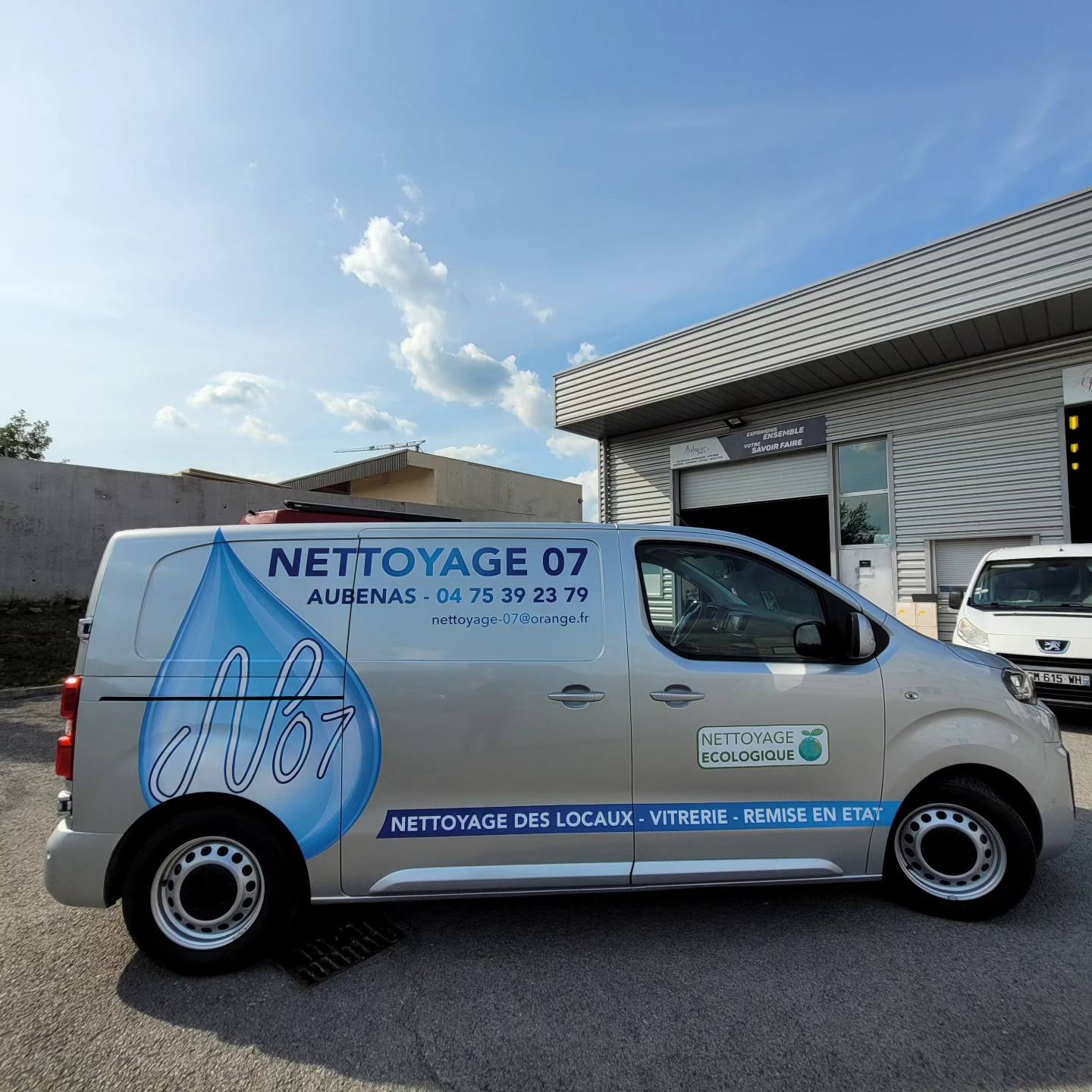 Marquage adhésif sur un Peugeot Expert gris pour Nettoyage 07 à Aubenas, avec une grande goutte d'eau bleue et la mention nettoyage écologique