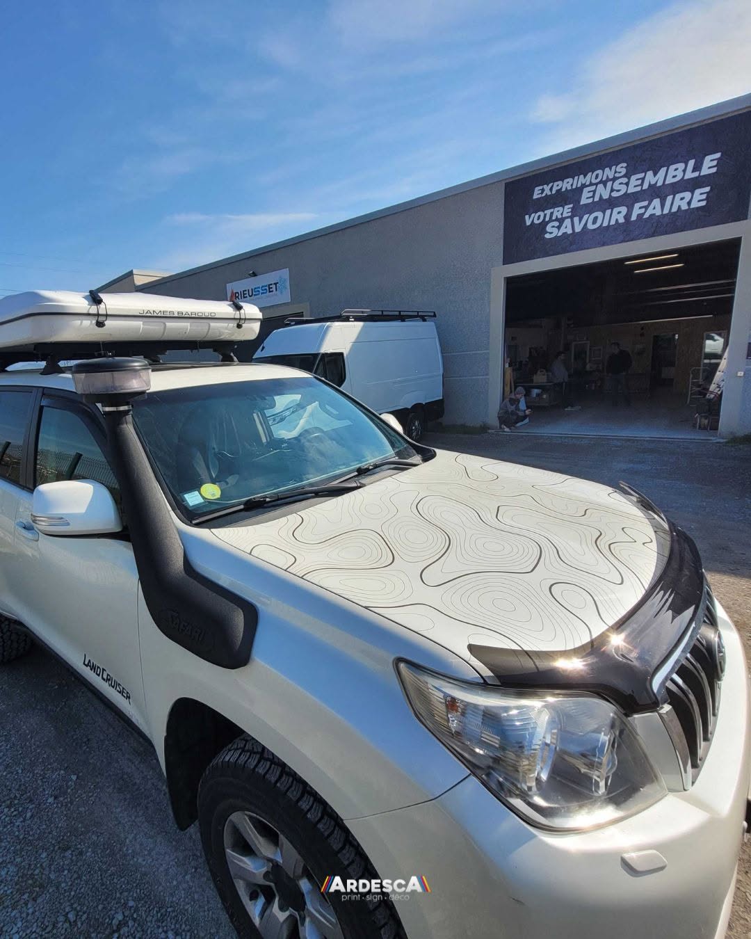 Covering du capot d'un Toyota Land Cruiser blanc avec un motif de courbes de niveau topographiques