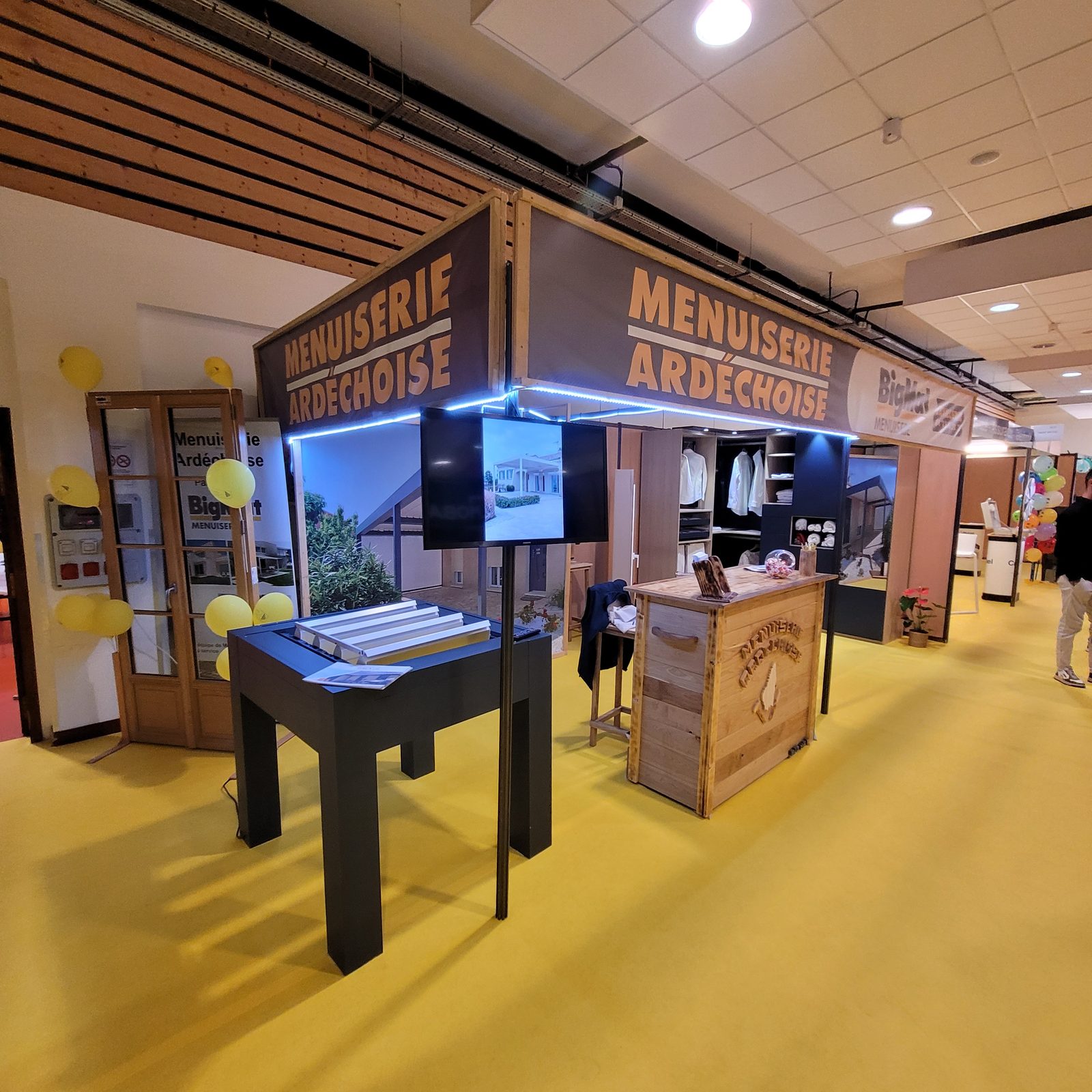 Stand de salon Menuiserie Ardéchoise BigMat équipé de deux banderoles imprimées tendues sur ossature bois