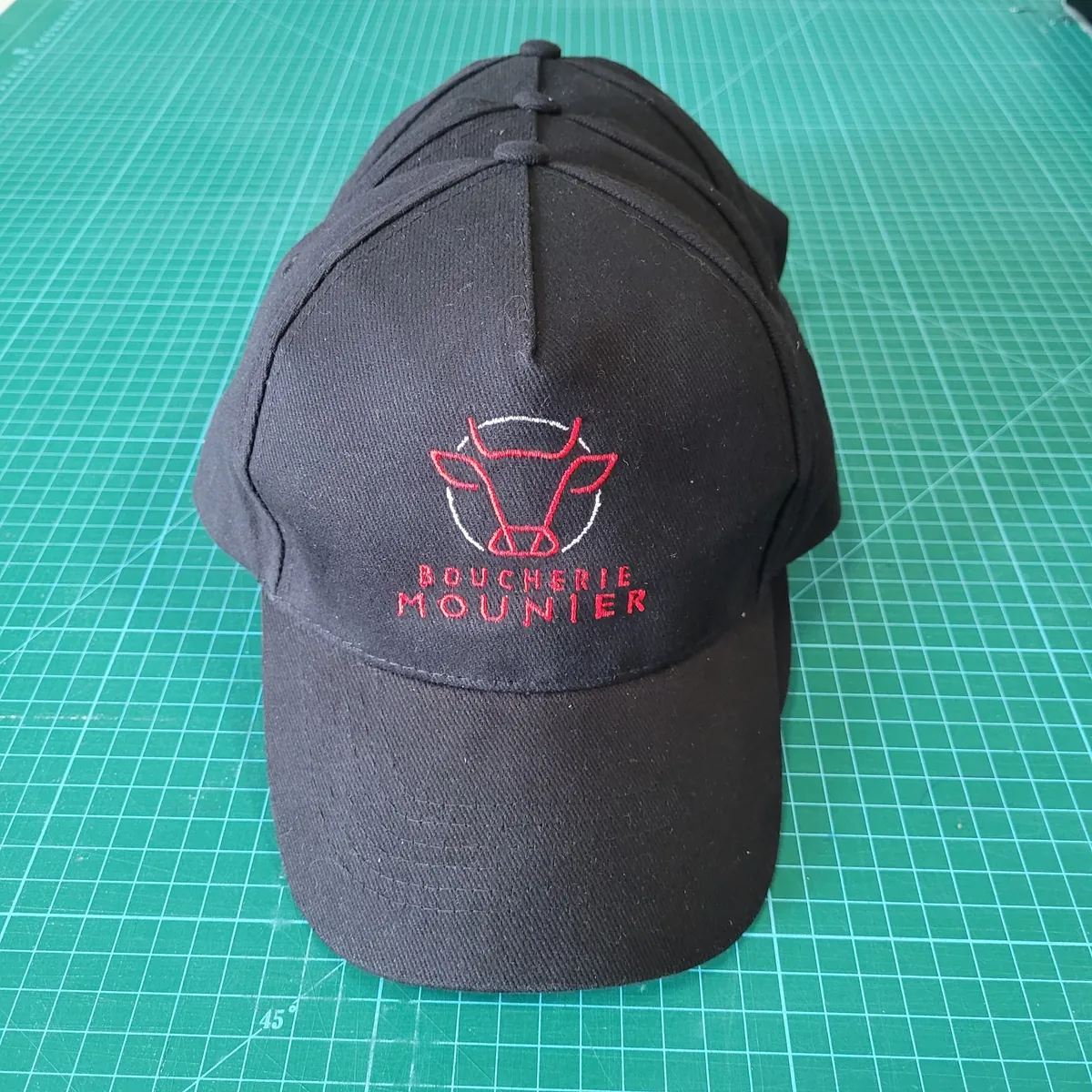 Casquette noire brodée du logo Boucherie Mounier, tête de bœuf stylisée en fil rouge et blanc