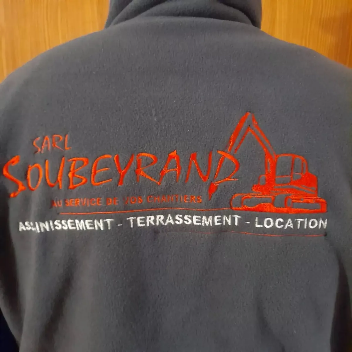 Polaire à capuche bleu marine brodée du logo SARL Soubeyrand en fil rouge et blanc