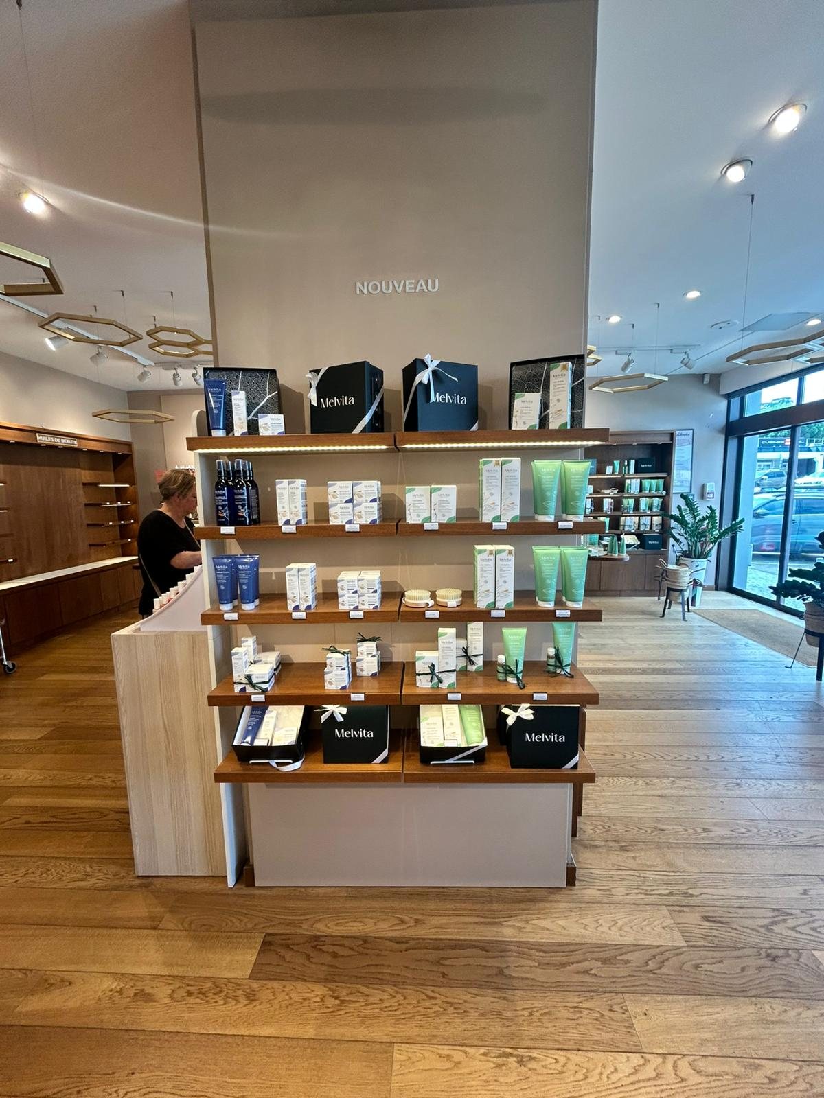Ilot central de la boutique Melvita avant habillage, mobilier bois fonce et parquet d origine