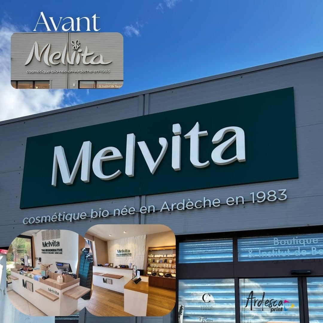 Enseigne Melvita en lettres relief blanches sur panneau dibond vert foncé, avec la baseline cosmétique bio née en Ardèche en 1983 en relief sur le bardage