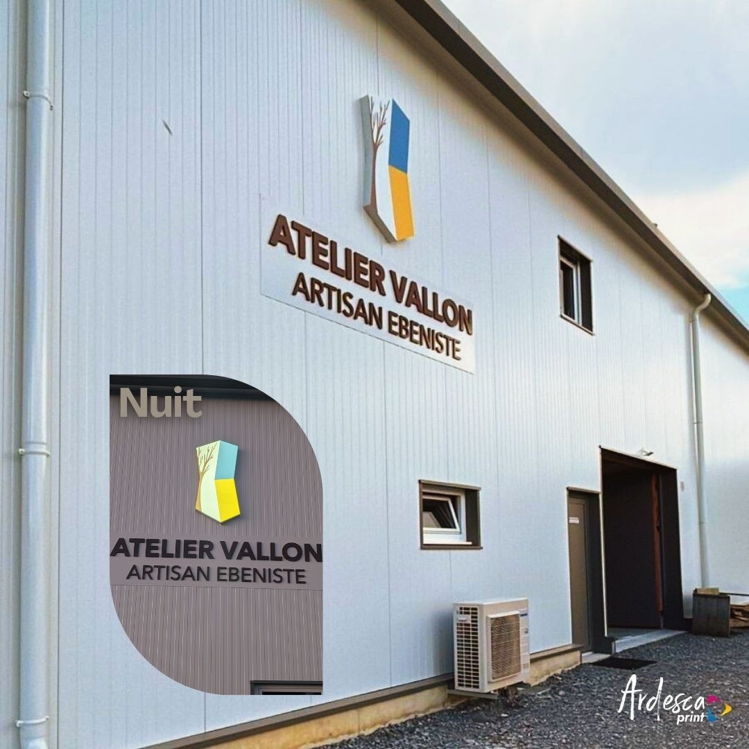 Enseigne Atelier Vallon artisan ébéniste en lettres relief sur bardage blanc, avec un encart montrant le rendu rétroéclairé de nuit