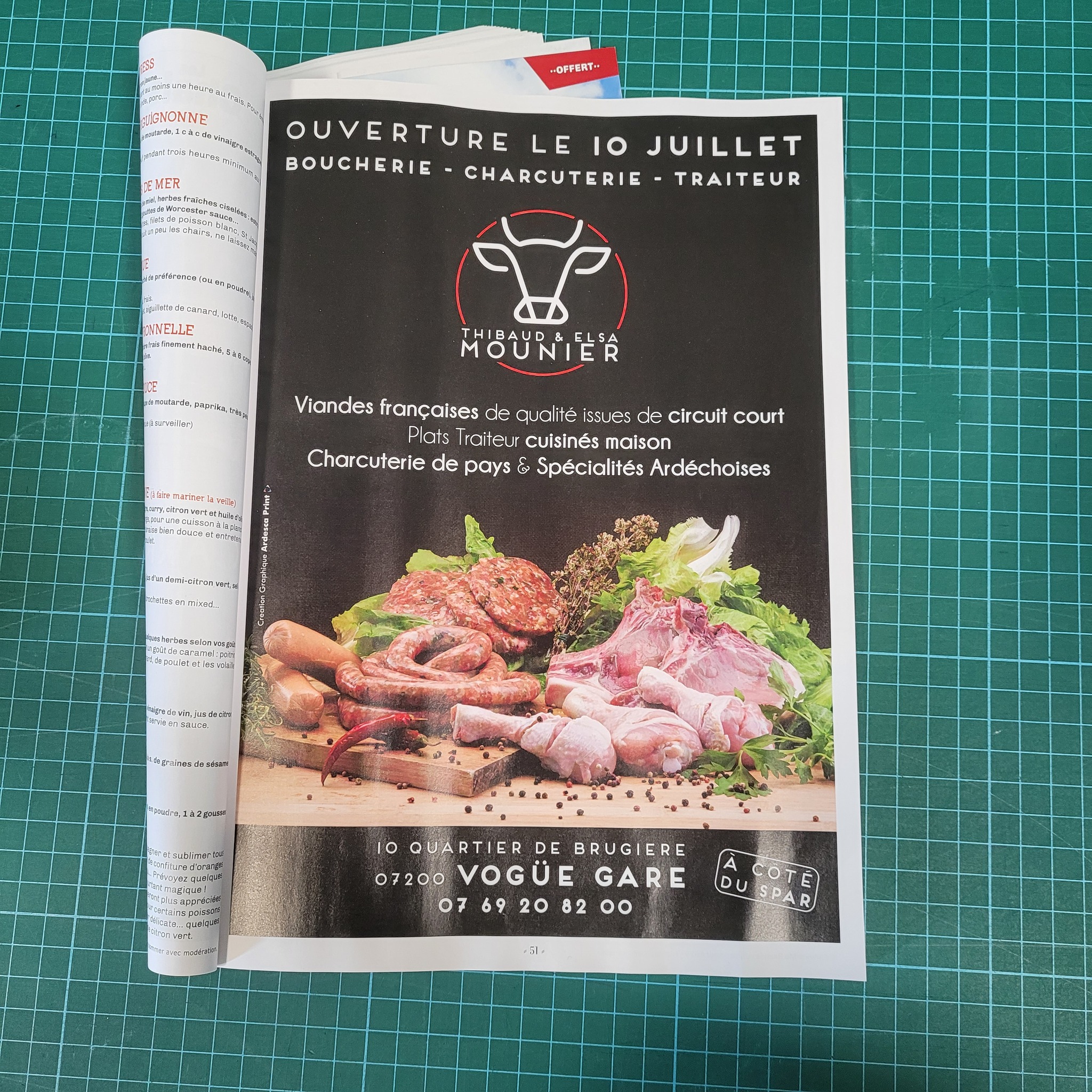 Encart publicitaire pleine page annonçant l'ouverture de la boucherie charcuterie traiteur Thibaud et Elsa Mounier à Vogüé Gare, dans un magazine posé sur un tapis de découpe