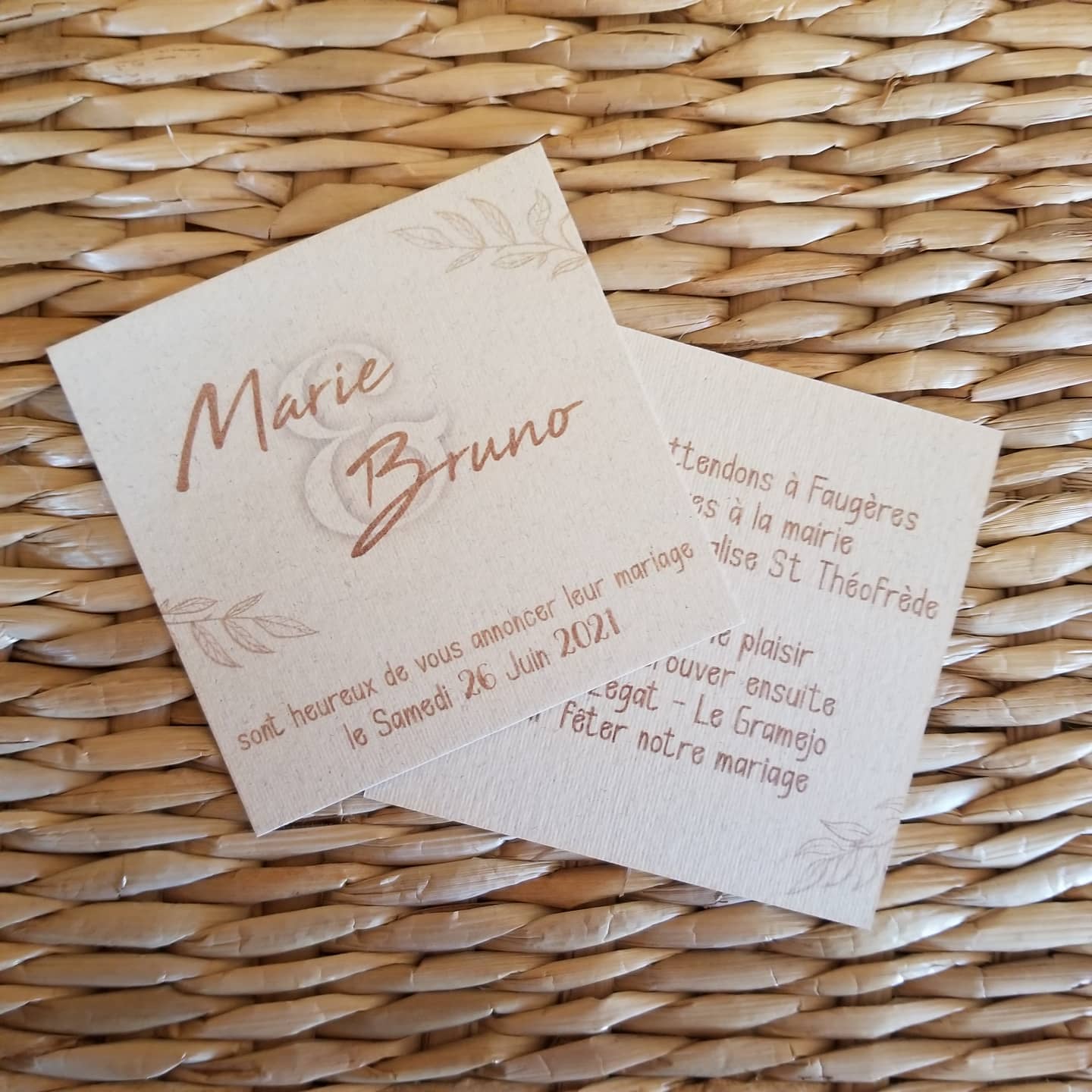 Faire-part de mariage carré imprimé en cuivre sur papier texturé naturel, posé sur un panier tressé