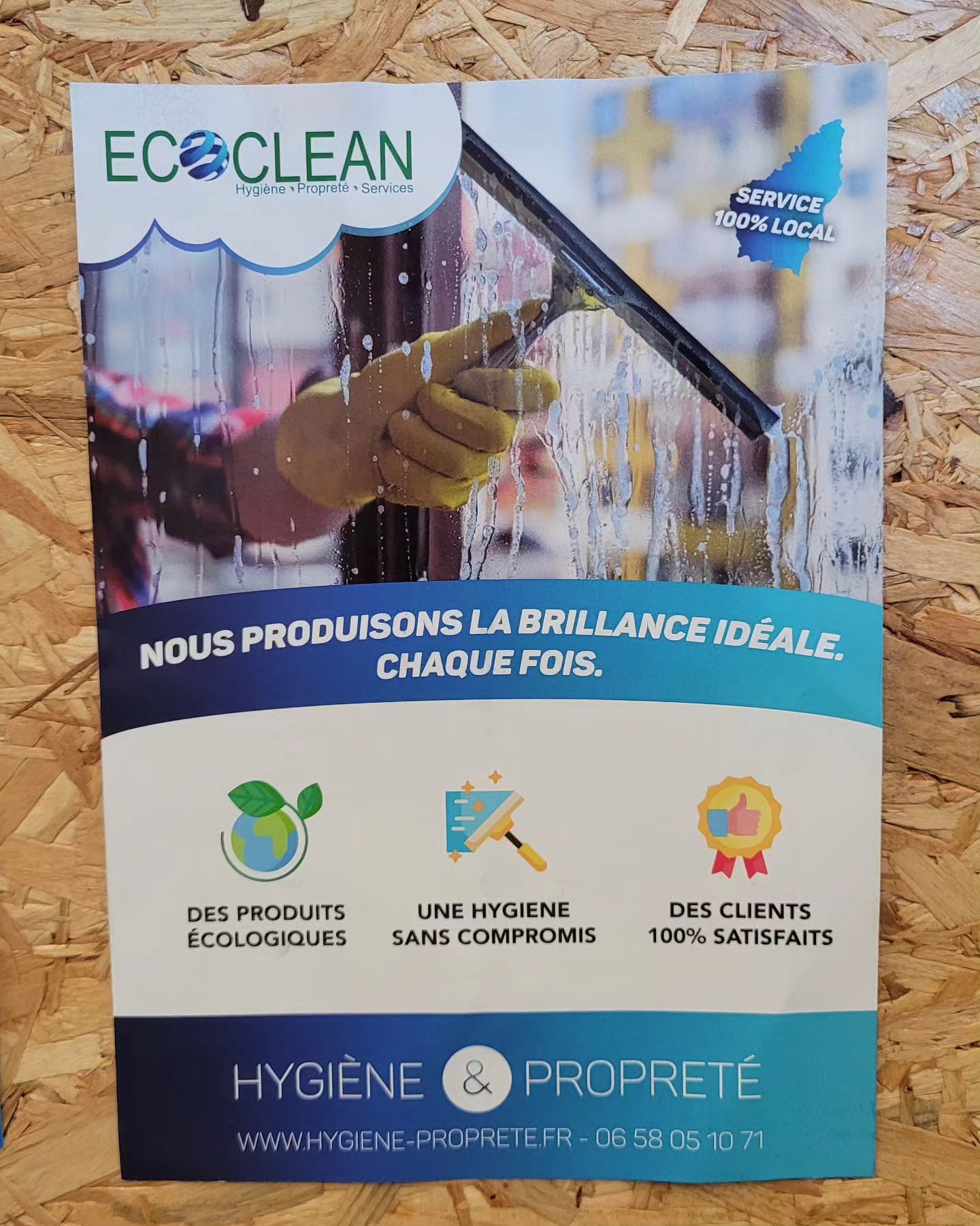 Flyer EcoClean, hygiène propreté services, slogan « nous produisons la brillance idéale », posé sur un panneau de bois OSB