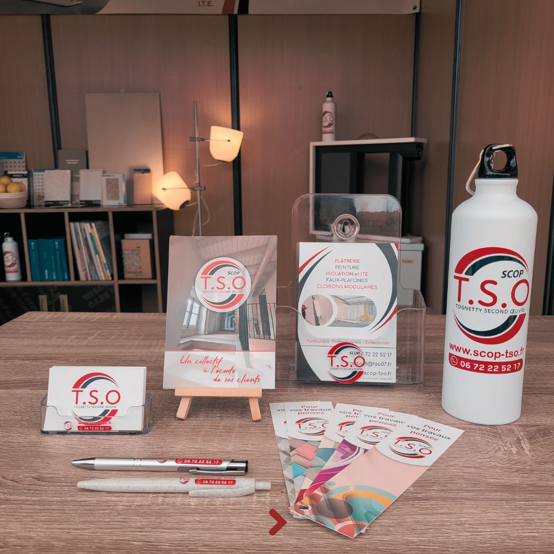 Ensemble de supports T.S.O Tognetty Second Œuvre : cartes de visite, chevalet, présentoir à flyers et dépliants sur un bureau