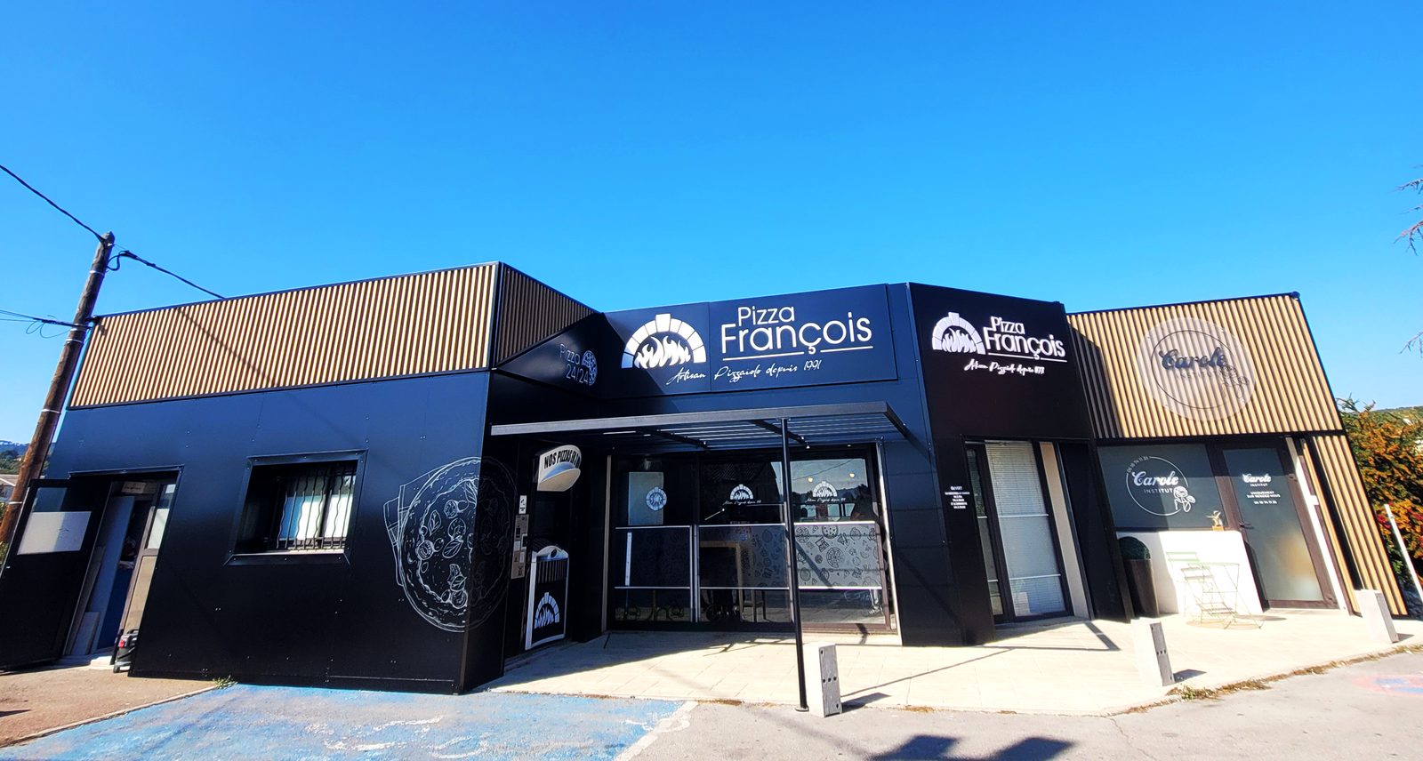 Façade de Pizza François entièrement habillée en noir avec logos et décor